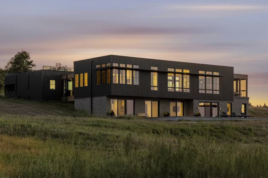 midcentury-inspired home set in prairie field at dusk