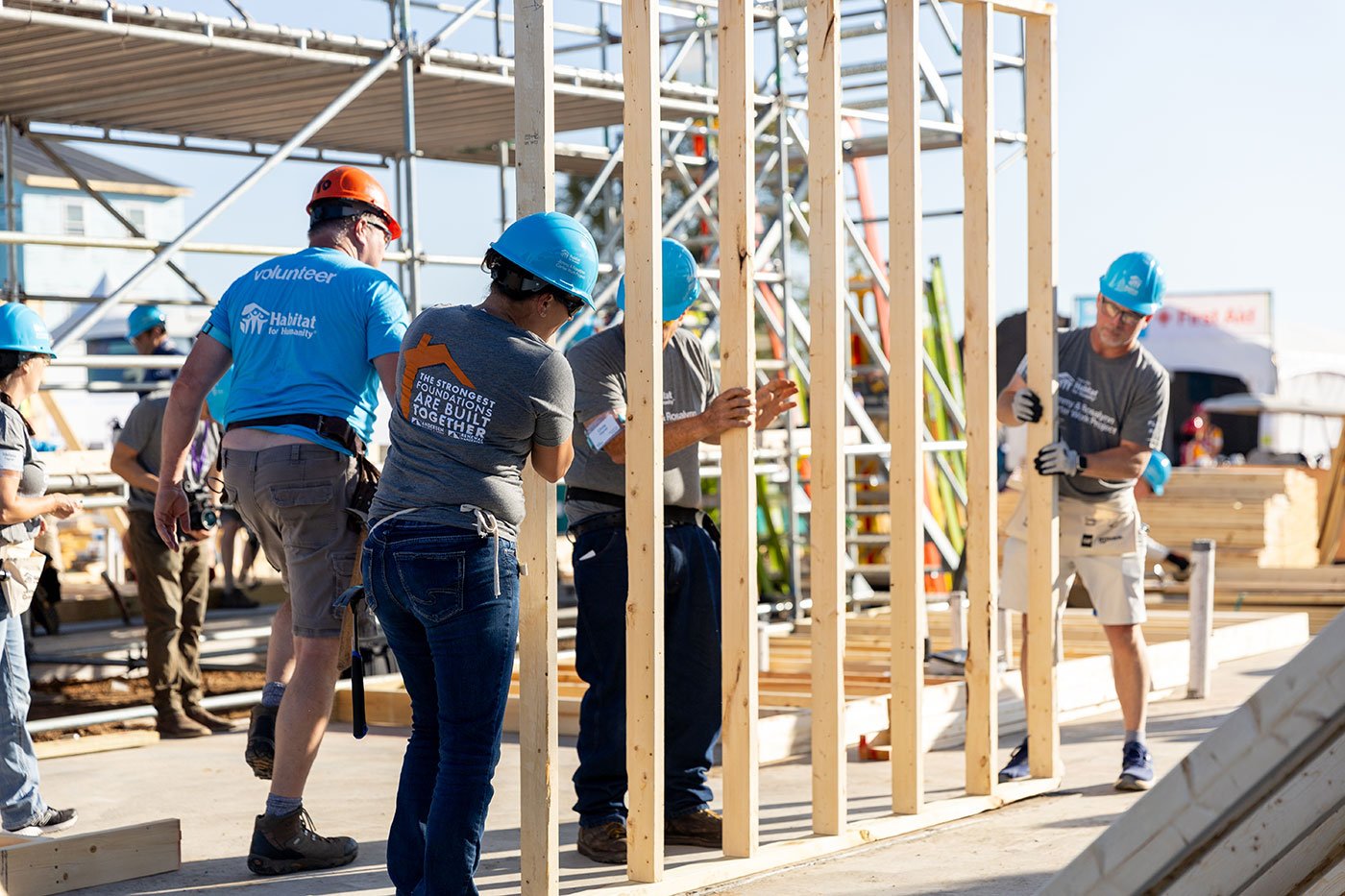 Group of volunteers helping stand up framing wall