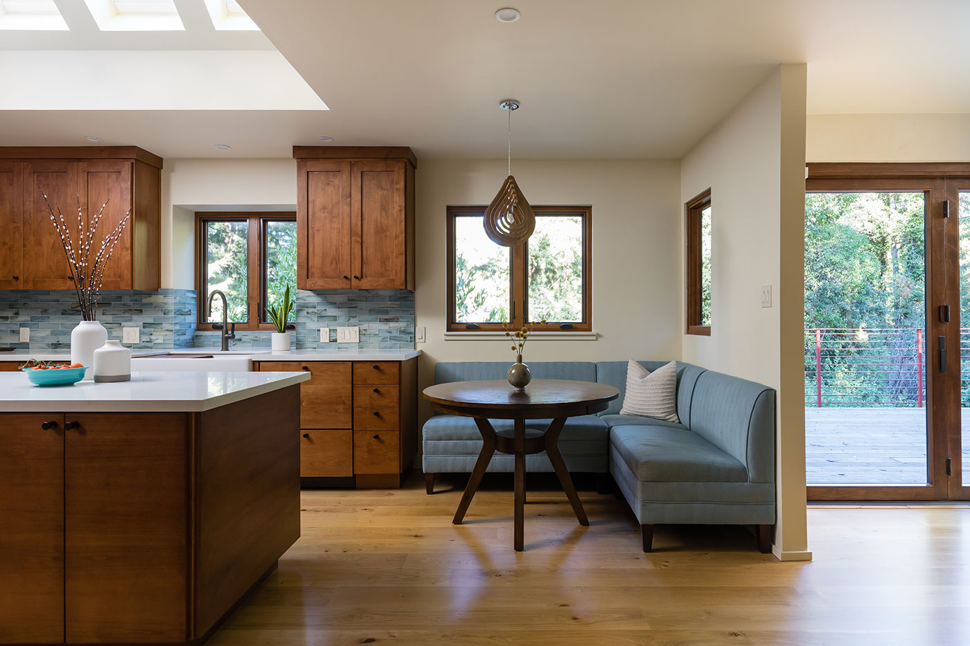A kitchen with dark wood cabinetry and wood frame windows to match is next door to a Folding Outswing Door.