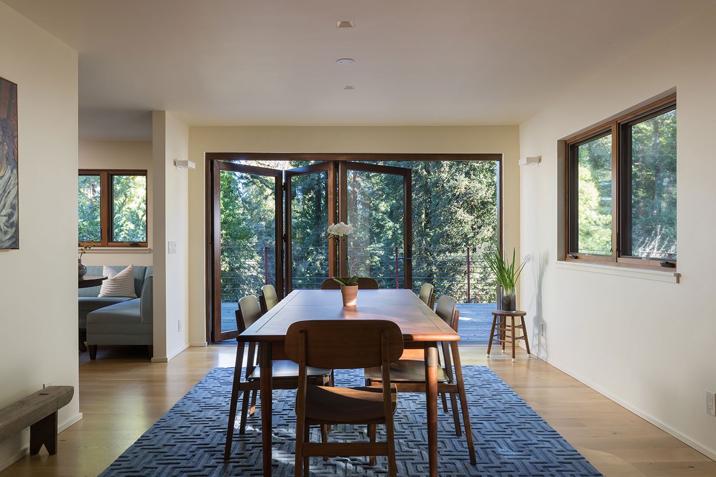 A dining room facing a Folding Outswing Door that connects with a deck.