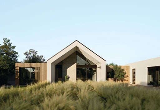 contemporary home in green field with blue sky