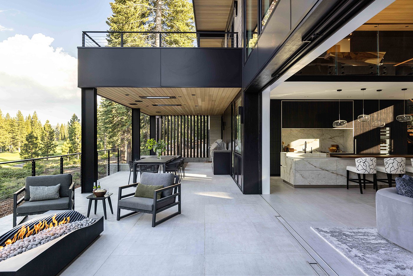 An open Liftslide Door connecting an open-concept indoor space with a terrace outside.