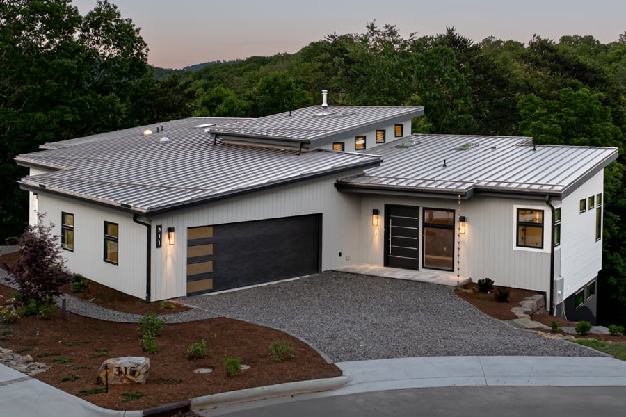 A low-slung modern home with a white exterior and black windows.