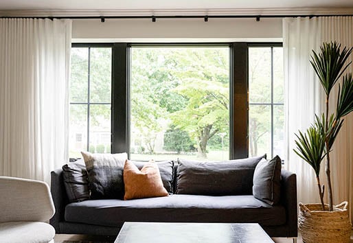 living room with blue couch and Andersen bay window in black