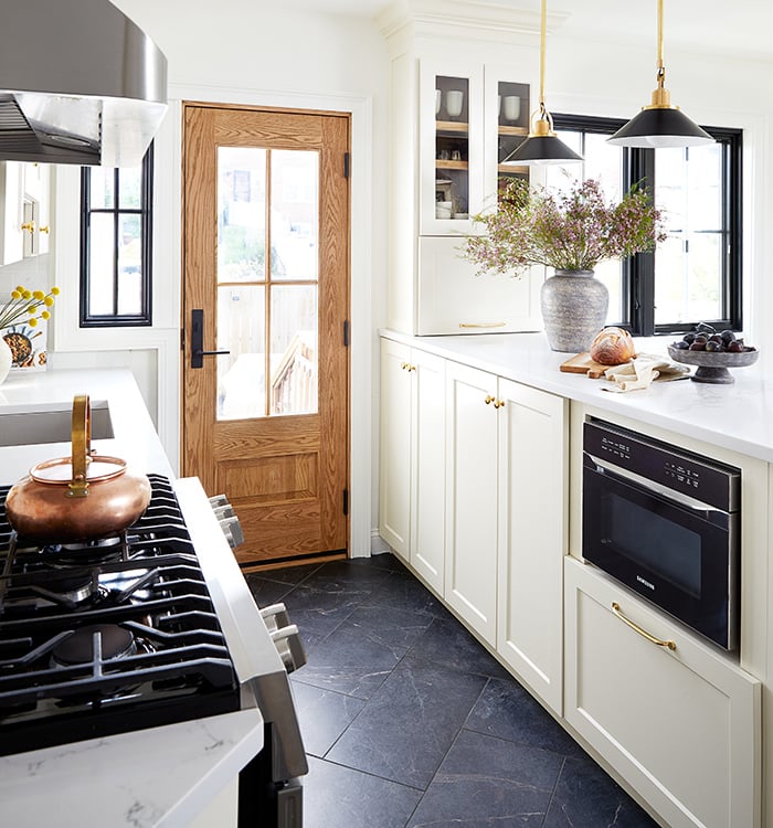 A front door after a replacement in a kitchen setting (shown on the right) and a before picture of the old front door (show on the left).