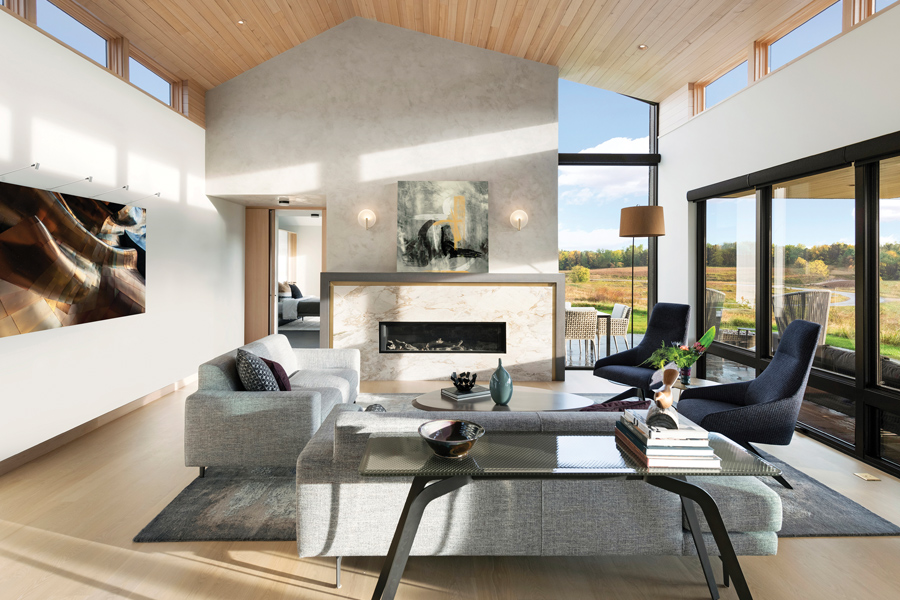 A modern living room with clerestory windows on both sides and a wood clad ceiling.