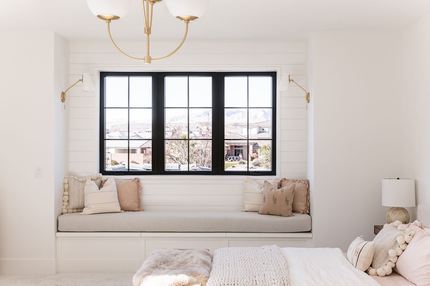 A child’s bedroom with three black-framed windows.