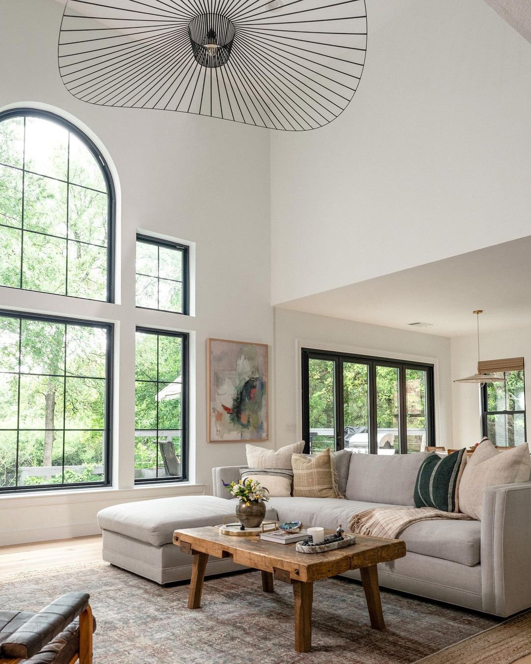 A double-height living room with Andersen 100 Series Windows, including a large arched window