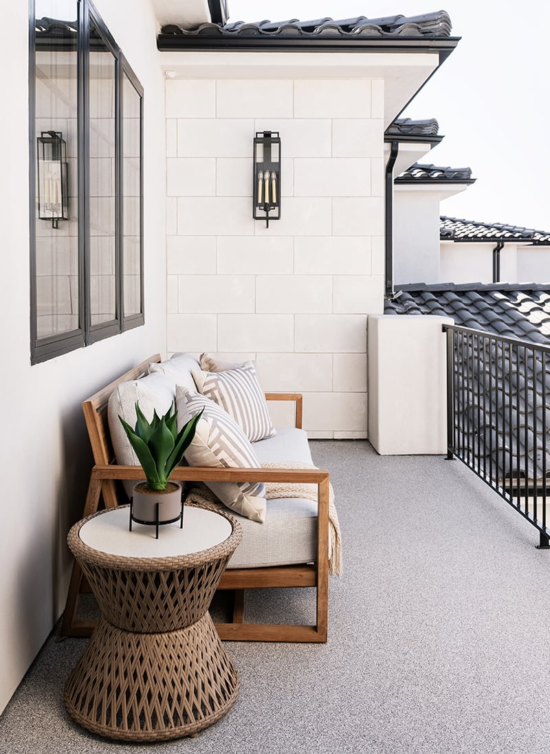 A balcony on a Spanish-style home with black tile roof and black-framed Andersen 100 Series Casement Windows.