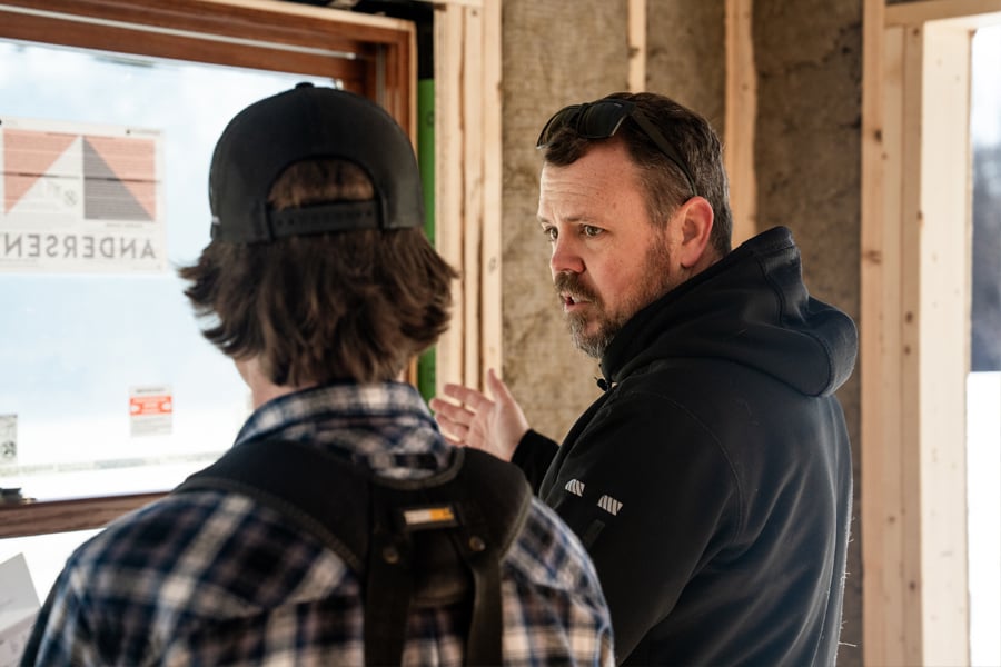 A builder talks to one of his crew while onsite.