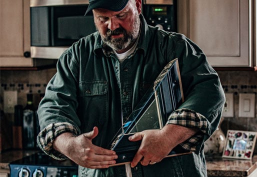 contractor in homeowners kitchen giving renovation ideas holding window sample