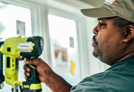 contractor using drill to install anderson window