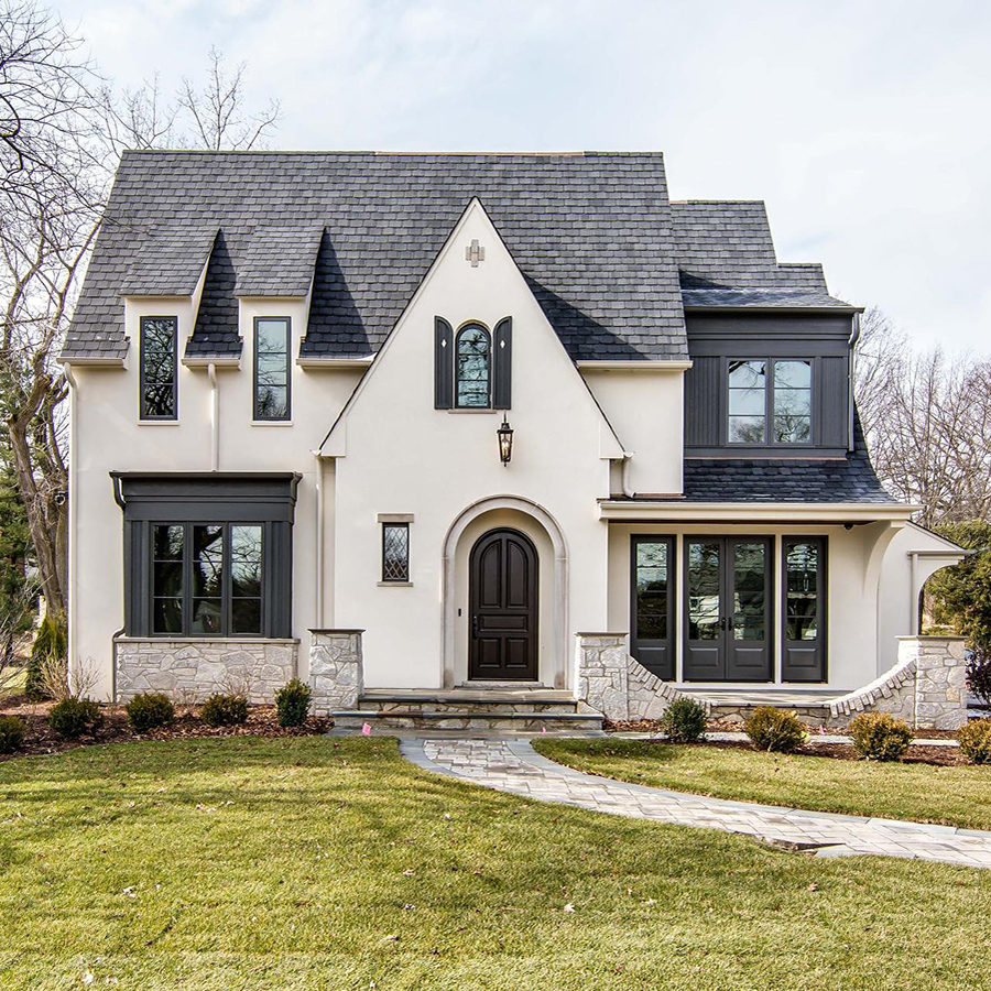 A before picture of a home under construction and an after image of a new construction Tudor-style home.
