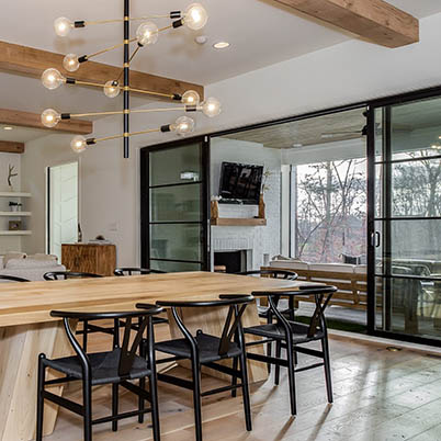 contemporary dining room with large table and black framed Andersen windows