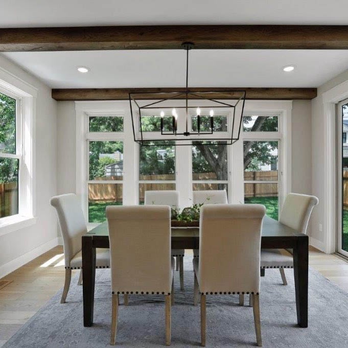 Formal white and wood dining room with white windows