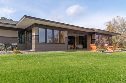 exterior of home with green grass and black framed Andersen windows