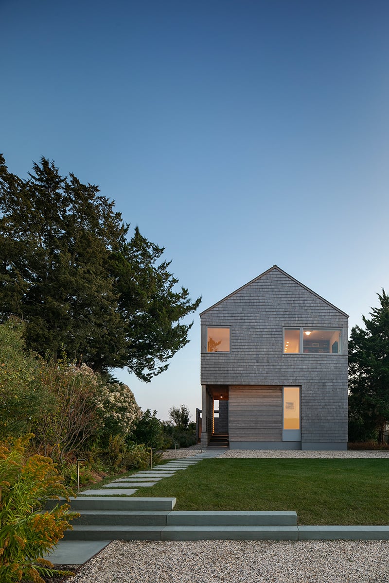 A house with a gable roof, cedar shingles, and E-Series picture windows. 