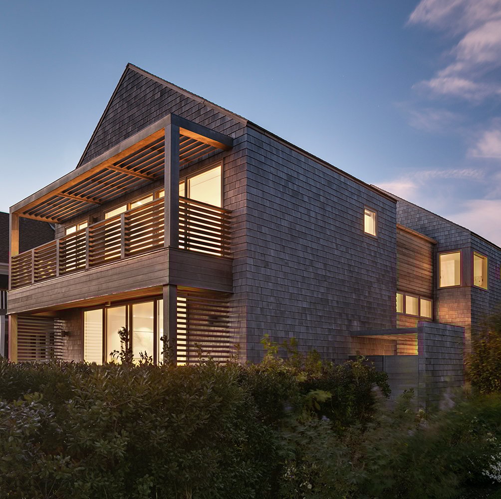 A two-story home with balconies on each level and cedar shingles.