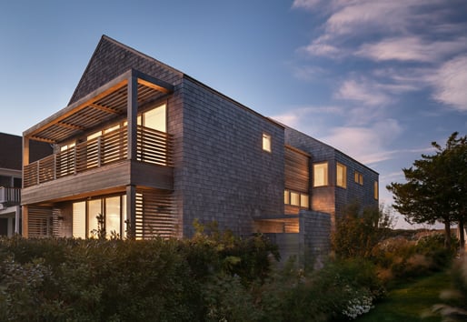 A two-story home with balconies on each level and cedar shingles.