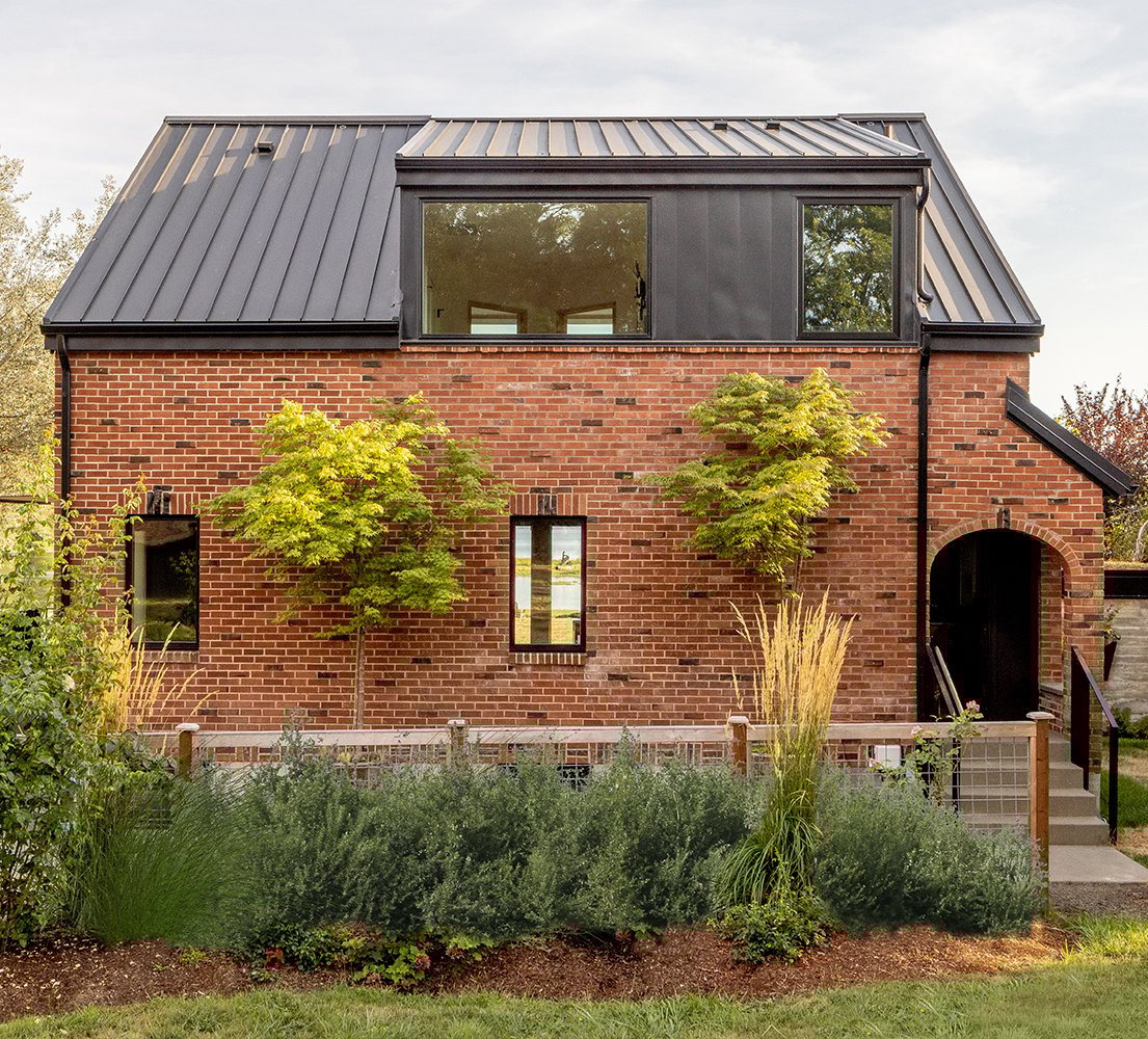 The back of a brick cottage with E-Series casement and picture windows.