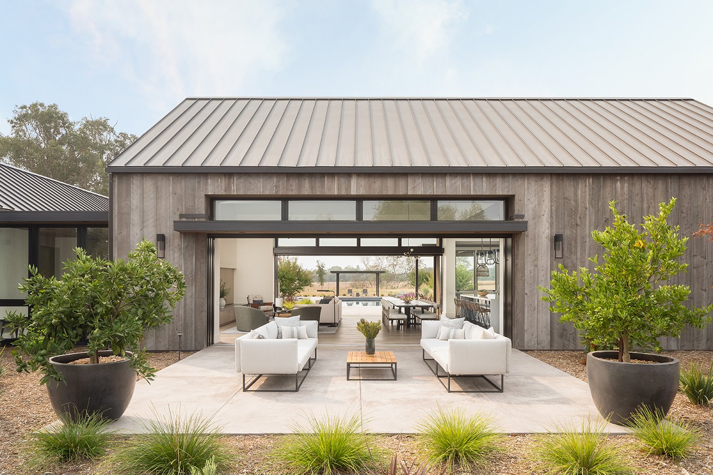 Two Andersen® Liftslide Doors connect a front yard to backyard through an indoor living area