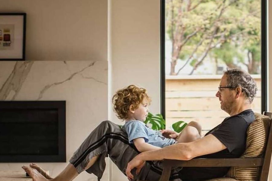 child sitting on mans lap in livingroom with andersen 400 series worry-free windows