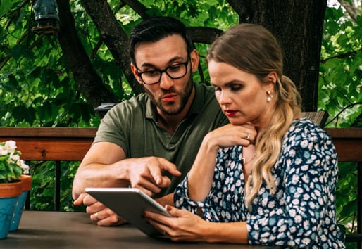 Couple looking at an eye pad in conversation
