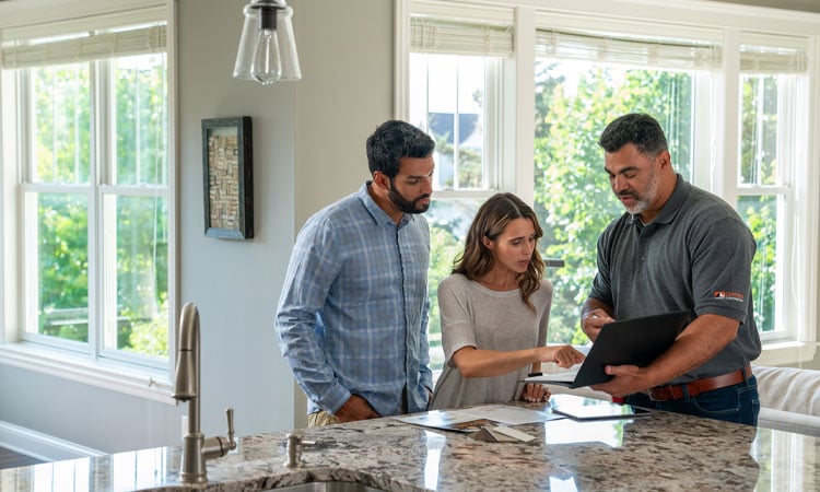 homeowners and contractor going over pricing in kitchen