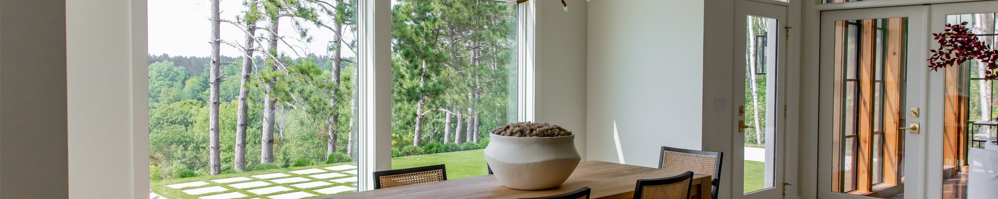 Cozy dining room with 400 Series picture and transom windows overlooking pretty backyard