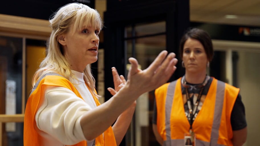 Andersen employee in show room talking wearing orange vests