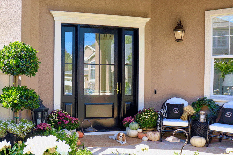 A black front door with sidelight makes a bold statement on this white painted house.
