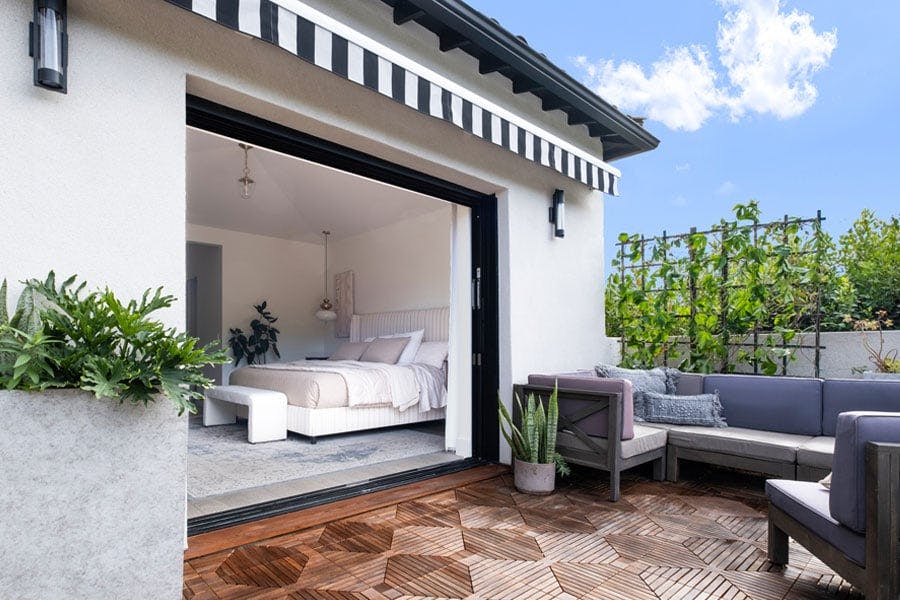 An exterior shot showing a bedroom that connects to a balcony via a pocketing MultiGlide™ Door. 