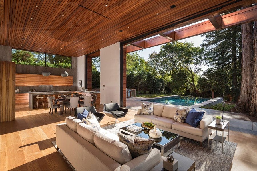 A moveable wall opens this living room to the pool and patio outside