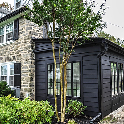 brick home with black siding accents with black framed Andersen windows