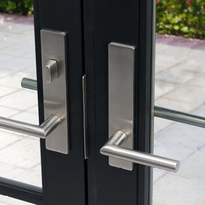 close up image of andersen stainless steel door hardware on black door