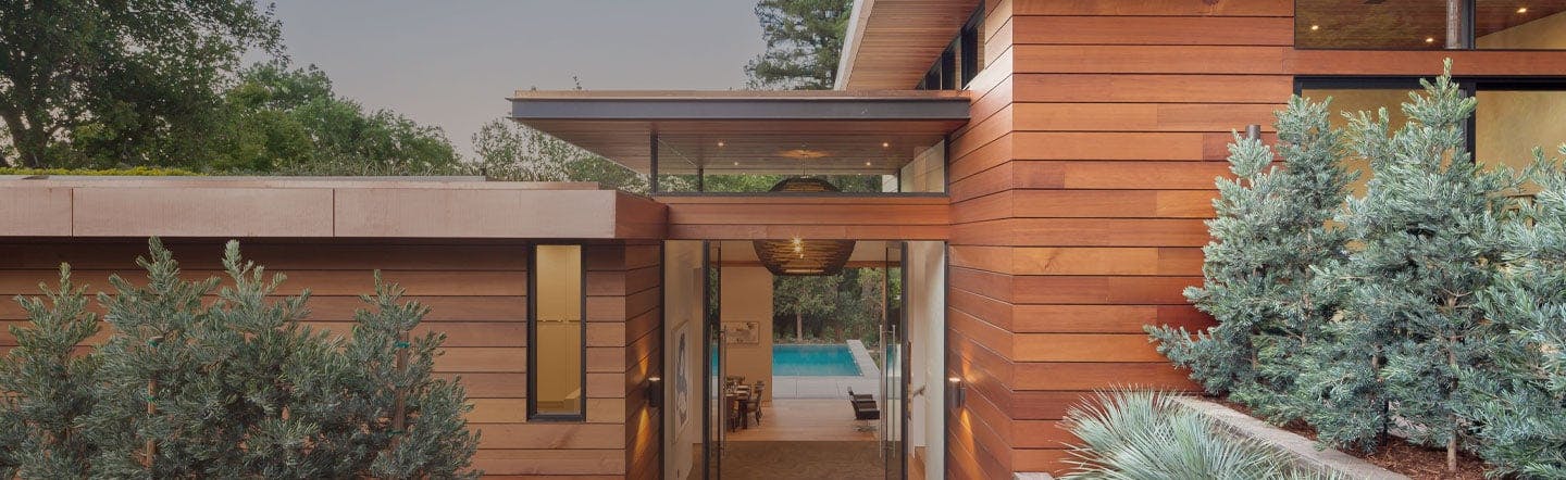 contemporary home with wood exterior and pool